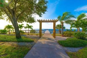 拉斯金Beautiful New Luxury Townhome with Private Beach and Swimming Pools的一条拥有木拱和棕榈树的小径