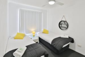 米尔迪拉112号橄榄公寓的白色客房的两张床,配有镜子