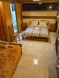 萨迈帕塔Peña Alta Samaipata的一间卧室配有一张床和一把椅子