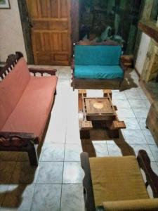 萨迈帕塔Peña Alta Samaipata的客厅配有几把椅子和一张沙发