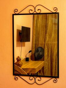 帕纳哈切尔Casa Esperanza的墙上的镜子,配有带风扇的桌子
