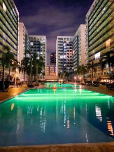 马尼拉Madison Place at Sea Residences powered by Cocotel的城市里的一个大型的绿色水泳池