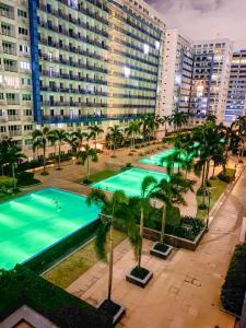 马尼拉Madison Place at Sea Residences powered by Cocotel的享有棕榈树和建筑的游泳池的顶部景致