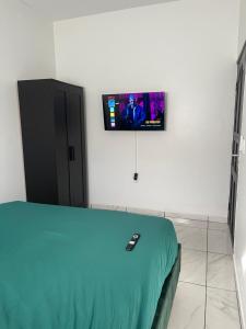 帕拉马里博Boa vista appartementen的一间设有床铺的客房,墙上配有电视