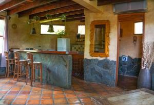 塔马林多Hotel Boruca Tamarindo的一间厨房,内设一个柜台和凳子