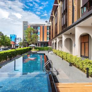 罗勇PLAAI Plus Hotel Rayong的建筑物一侧的游泳池