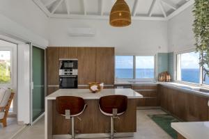 黎明海滩Oceanview Luxury Villa Escape的一个带大岛的厨房,配有两个酒吧凳
