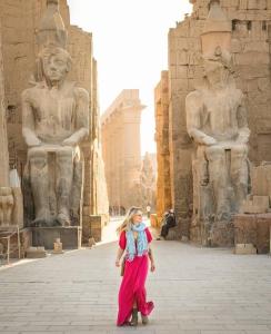 开罗Momen Pyramids Inn的一位妇女走在一些雕像前面