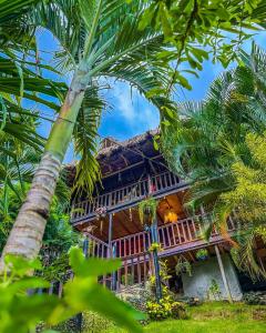 埃尔扎伊诺Villa Tayrona的前面有棕榈树的房子