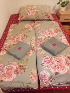 Liptovský Svätý PeterApartmán Eva的一张带两个枕头的床铺,上面有粉红色玫瑰