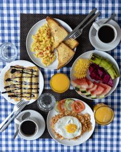 吉利特拉旺安Gili Ocean Club - ADULTS ONLY的餐桌上摆放着早餐食品和咖啡盘