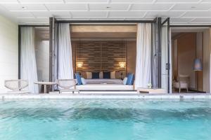 华欣Cape Nidhra Hotel的酒店客房带床和游泳池