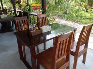 甲米镇Bangkaew Camping place bangalow的一张带两把椅子的木桌和一张带香料的桌子