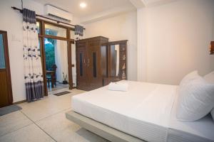 高尔D2 Villa Unawatuna的卧室配有一张白色大床