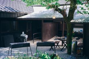 田边市熊野四季亭的庭院设有两把椅子和一张桌子,还有一棵树