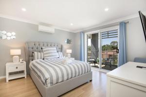 卡拉拉海滩Bluewater Jervis Bay - Pet Friendly with Spa的一间白色卧室,配有床和阳台