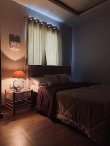 因帕尔Sunset Homes Imphal的一间卧室配有一张床和一张带台灯的桌子