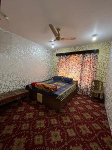 斯利那加Hotel Kashmir Heaven的壁纸客房内的一间卧室配有一张床