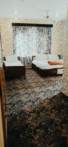 斯利那加Hotel Kashmir Heaven的铺有地毯的客房内的两张床