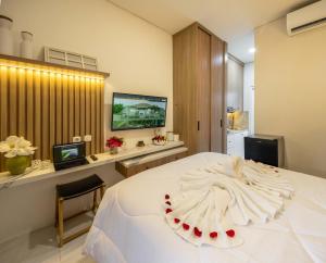 登巴萨Verdant Bali Sekar Sari的卧室配有一张白色大床和电视。