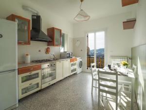 阿尔玛·迪·塔吉亚Casa del Sole的厨房配有白色家电和桌椅