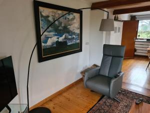 比特亨巴赫Haus Päsch nahe See mit beheiztem Whirlpool/Sauna的客厅配有椅子和墙上的绘画