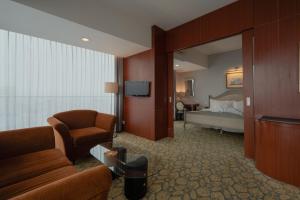 泗水The Capital Hotel Surabaya的酒店客房设有床和客厅。