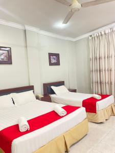 巴生Bayu View Hotel Klang的一间卧室配有两张红色和白色床单