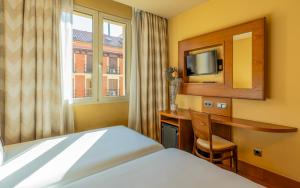 马德里斯特林酒店的酒店客房配有一张床、一张书桌和一台电视。