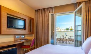 马德里斯特林酒店的酒店的客房 - 带一张床、一台电视和一个阳台