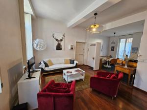 第戎巴斯德公寓的客厅配有沙发和2把红色椅子