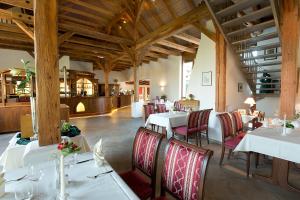 格里马Hotel Kloster Nimbschen 4 Sterne的用餐室配有白色的桌子和红色的椅子