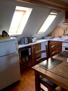 Hohen SprenzFerienwohnung am Papensee的厨房配有天窗、桌子和冰箱。