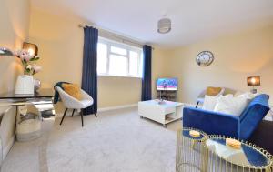 温彻斯特Charming 4-Bed House in Winchester Free Parking的客厅配有蓝色的沙发和电视