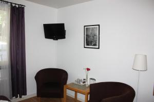 埃斯基尔斯蒂纳里拉旅馆的一间设有两把椅子和一张桌子的房间,墙上设有一台电视机