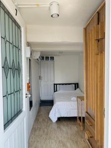 Ban Bang PhlatChubby 9 Room 7的一间小卧室,配有一张床和一扇门
