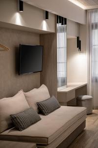 干尼亚CASA DORINI的卧室配有一张壁挂式平面电视的床。