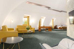 格里马Hotel Kloster Nimbschen 4 Sterne的客厅配有黄色椅子和桌子