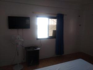 波尔多·格尼拉Kaye En Em Apartelle的卧室设有窗户、电视和风扇。