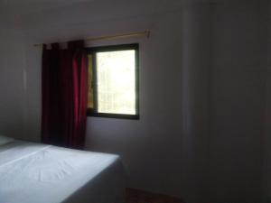 波尔多·格尼拉Kaye En Em Apartelle的一间卧室设有一张床和一个窗口