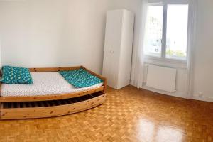诺伊斯·勒·格兰德Appartement bien situé的一间卧室设有一张木床和一个窗户。
