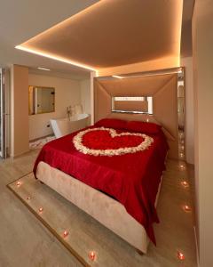 蒙特卡蒂尼泰尔梅Secret Suites Panoramic的一间卧室,配有一张由玫瑰制成的心床