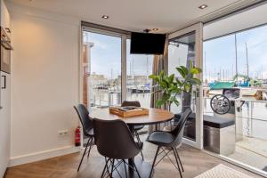 泽沃德Luxurious waterloft near beach and centre的一间带桌椅和大窗户的用餐室