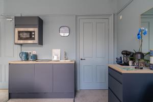 佩斯利Bluebell Studio Glasgow Airport的厨房配有白色橱柜和白色门