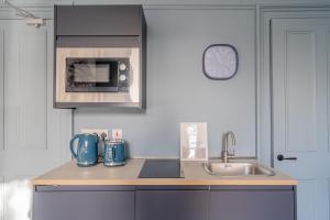 佩斯利Bluebell Studio Glasgow Airport的厨房配有水槽和微波炉