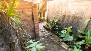 斯勒曼Rumah Gaharu - Kamar Ngarep 001的一座种植了植物的小花园,一座砖墙