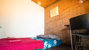 斯勒曼Rumah Gaharu - Kamar Ngarep 001的一间设有红色床和砖墙的房间