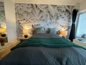 弗伦斯堡Flensburg Solitüde的一间卧室配有一张带壁画的大床
