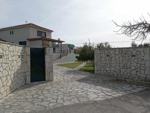 XilokéraLio's Villa的房屋前有门的石墙