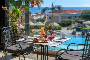 吉奥塔略林多斯帝国水疗度假村的一张桌子,上面有食物,享有游泳池的景色